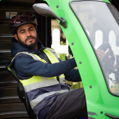 A cycle courier in hi-vis seated in a delivery vehicle