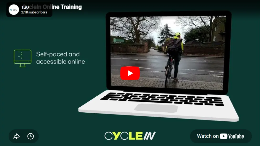 Two adults cycling along a protected cycle lane, shown as a preview of the CycleIn training video.